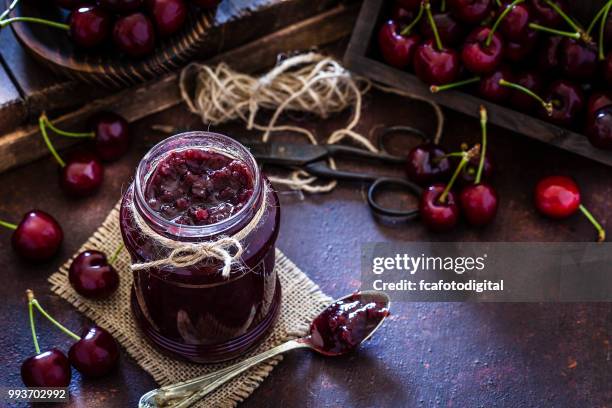 preparing homemade cherry jam on rustic kitchen table - jam jar stock pictures, royalty-free photos & images