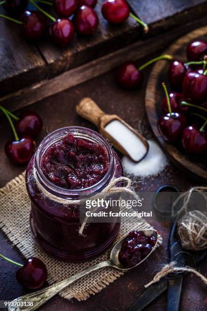 preparing homemade cherry jam on rustic kitchen table - marmalade stock pictures, royalty-free photos & images