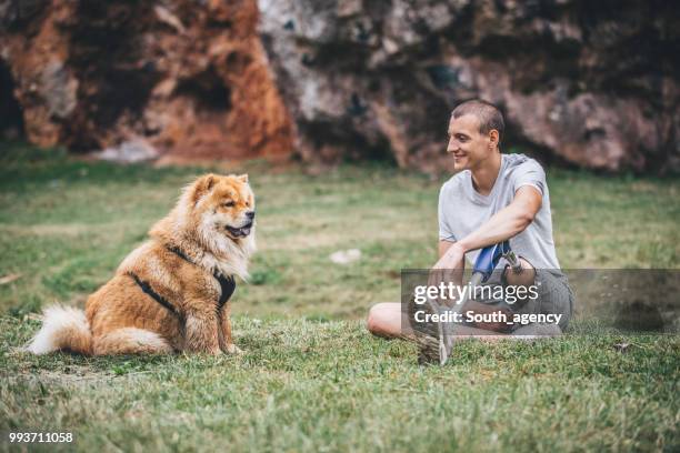 disability guy and dog relaxing - white chow chow stock pictures, royalty-free photos & images