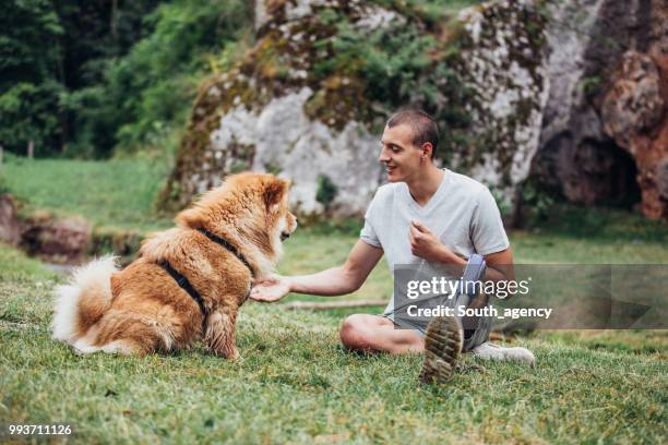 disability guy and pet relaxing - white chow chow stock pictures, royalty-free photos & images