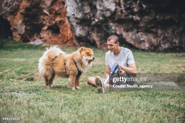 disability man and pet relaxing - white chow chow stock pictures, royalty-free photos & images