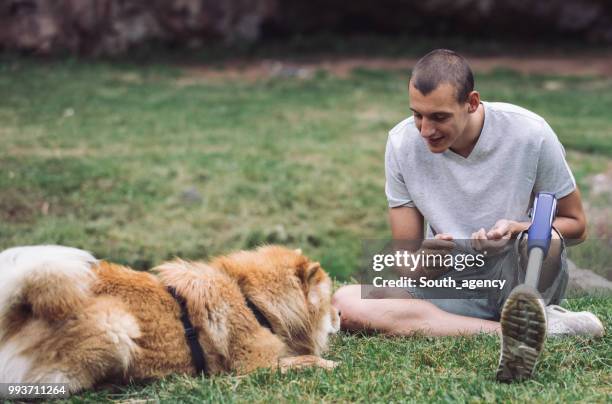 disability man and dog - white chow chow stock pictures, royalty-free photos & images