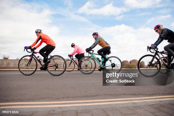 female cyclists on the road - girl power expressão inglesa imagens e fotografias de stock