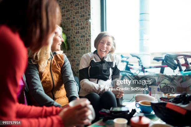 freundinnen gemeinsam lachen während kaffeetrinken in einem cafe - kaffeeklatsch stock-fotos und bilder