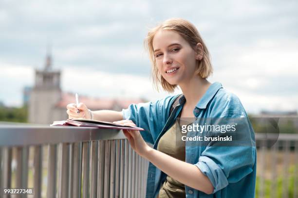 una giovane donna attraente di 20 anni disegna in un quaderno - 20 24 years photos foto e immagini stock