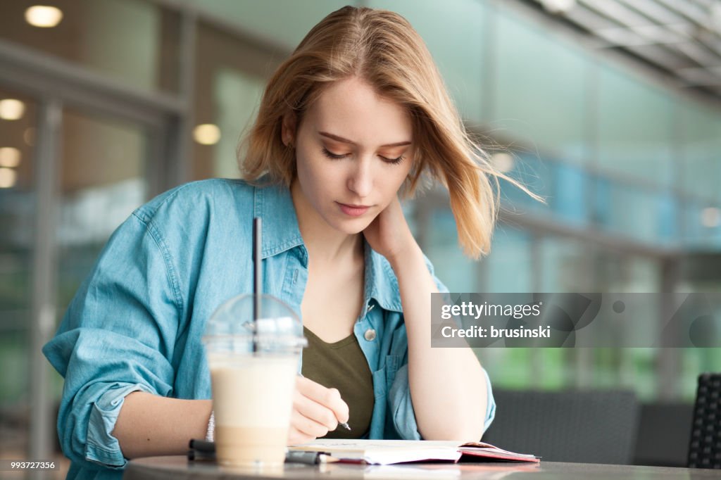 A young attractive woman of 20 years draws in a sketchbook