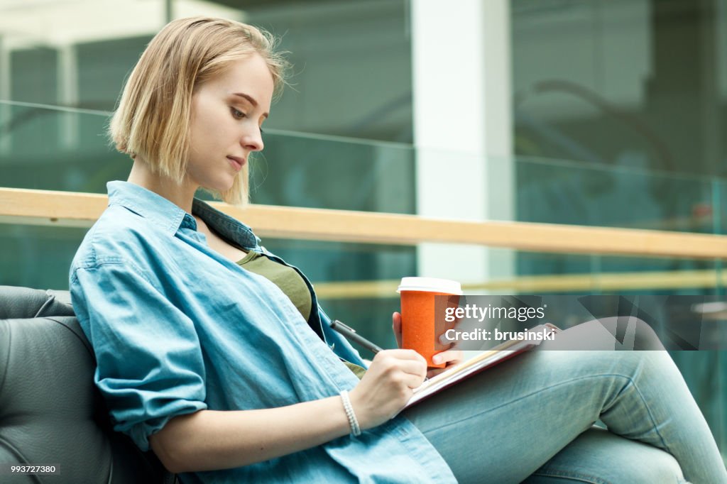A young attractive woman of 20 years draws in a sketchbook