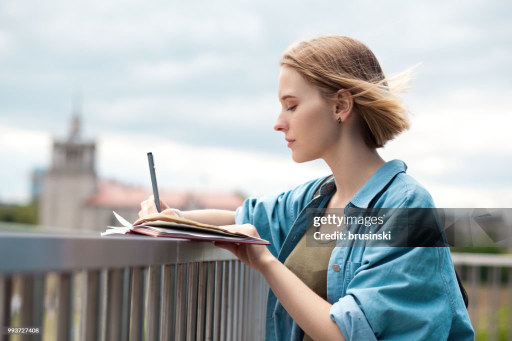 A young attractive woman of 20 years draws in a sketchbook