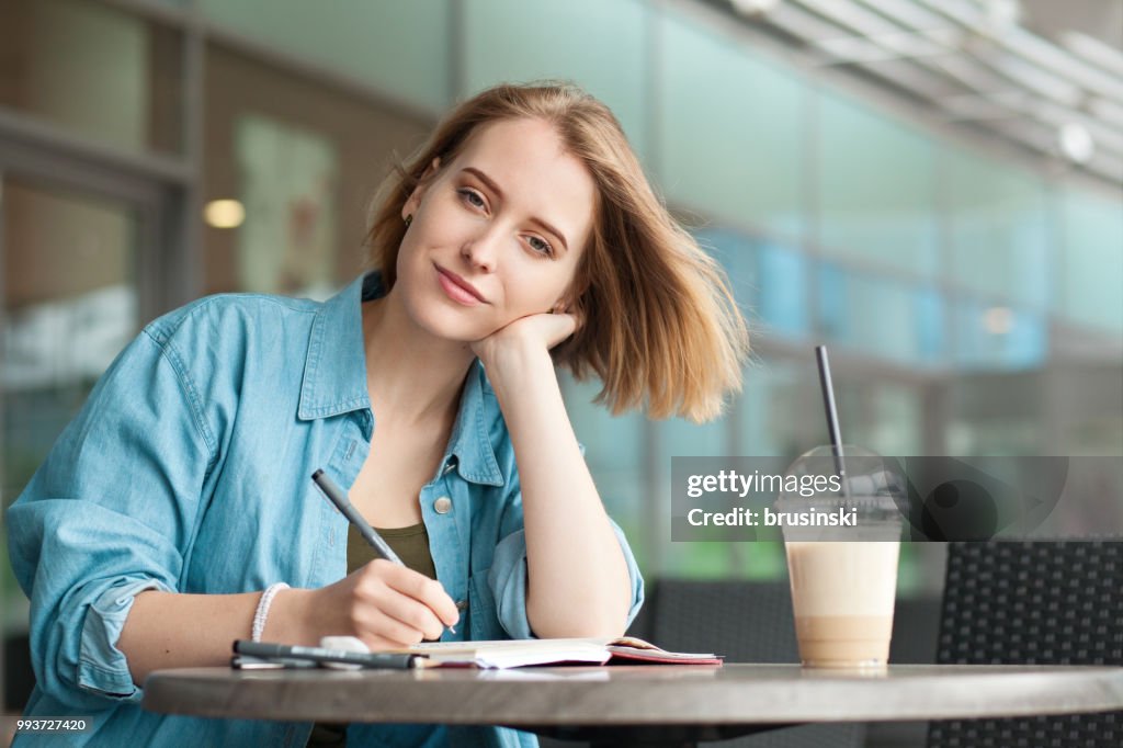 A young attractive woman of 20 years draws in a sketchbook