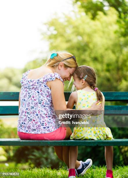 mother and daughter talking in the park - ivanjekic stock pictures, royalty-free photos & images