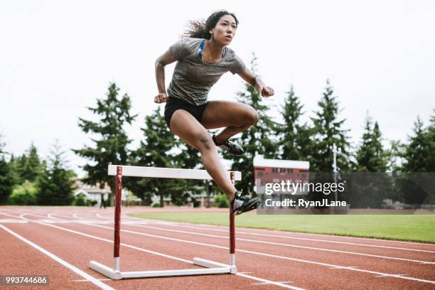 kvinna idrottsman löper häck för friidrott - spikskor för löpning bildbanksfoton och bilder