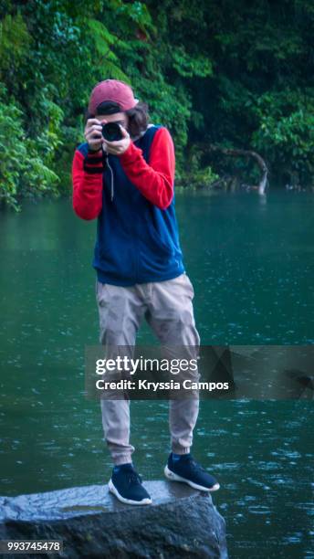 young man taking photos at tropical rainforest - alajuela stockfoto's en -beelden