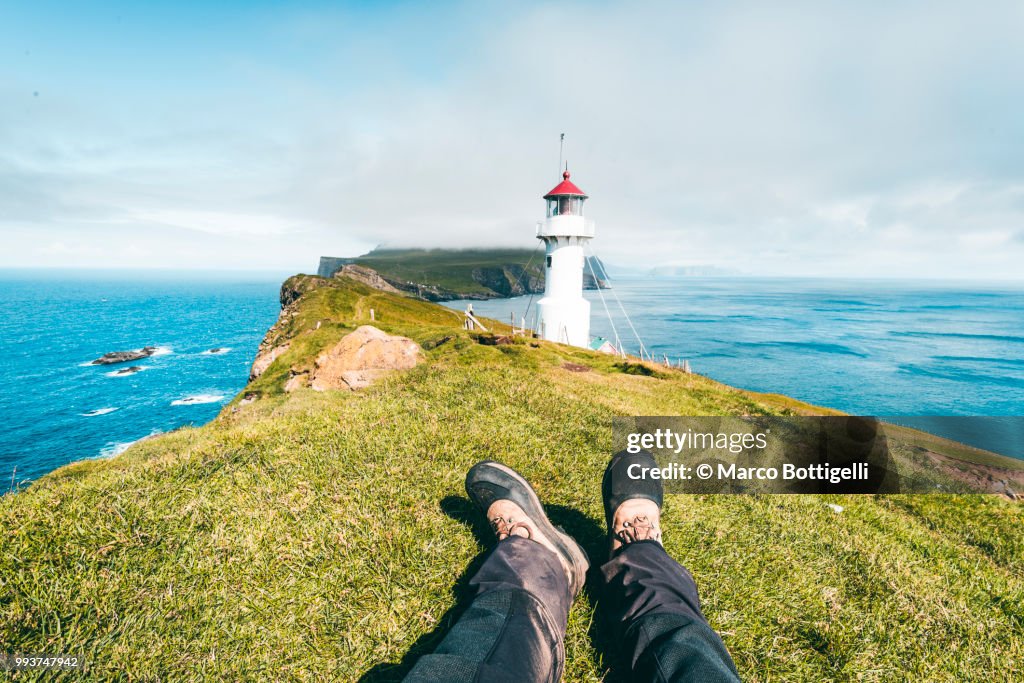 Tourist relaxing at the Mykines lighthouse