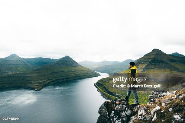 tourist admiring the wilderness in the faroe islands - marco bottigelli stock pictures, royalty-free photos & images