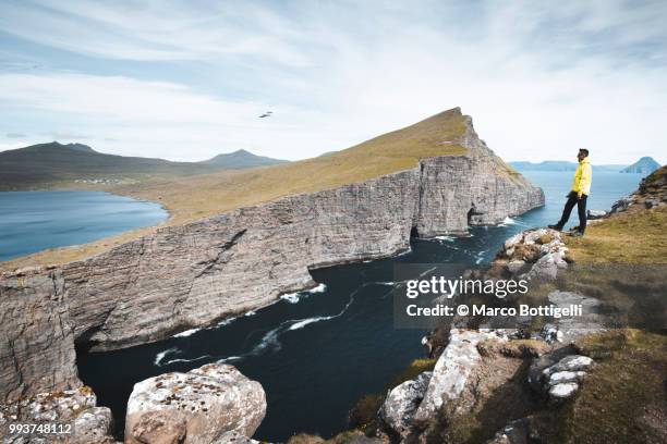 tourist admiring the wilderness in the faroe islands - marco bottigelli stock pictures, royalty-free photos & images