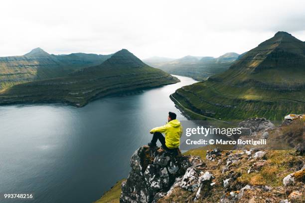 tourist admiring the wilderness in the faroe islands - denmark landscape stock pictures, royalty-free photos & images