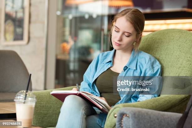 a young attractive woman of 20 years draws in a sketchbook - 20 24 years stock pictures, royalty-free photos & images