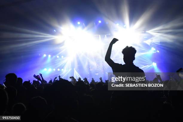 People attend US singer Rick Ross concert during the 30th Eurockeennes rock music festival on July 7, 2018 in Belfort, eastern France.
