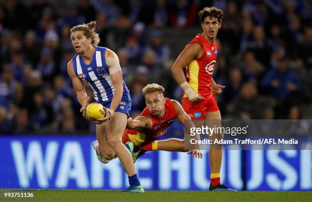 Jed Anderson of the Kangaroos evades Will Brodie of the Suns during the 2018 AFL round 16 match between the North Melbourne Kangaroos and the Gold...