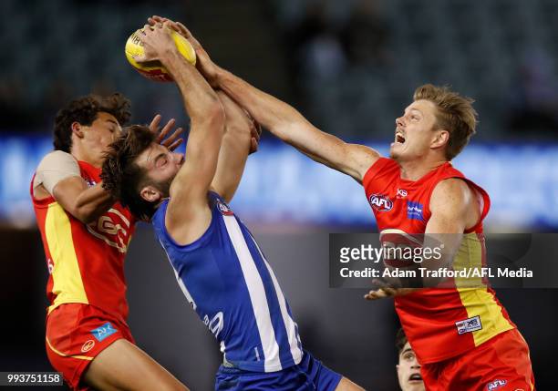 Luke McDonald of the Kangaroos marks the ball over Wil Powell and Nick Holman of the Suns during the 2018 AFL round 16 match between the North...
