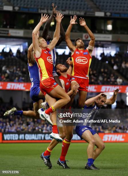 Majak Daw of the Kangaroos takes a huge mark over L-R Peter Wright, Jarrod Witts and Jack Martin of the Suns during the 2018 AFL round 16 match...
