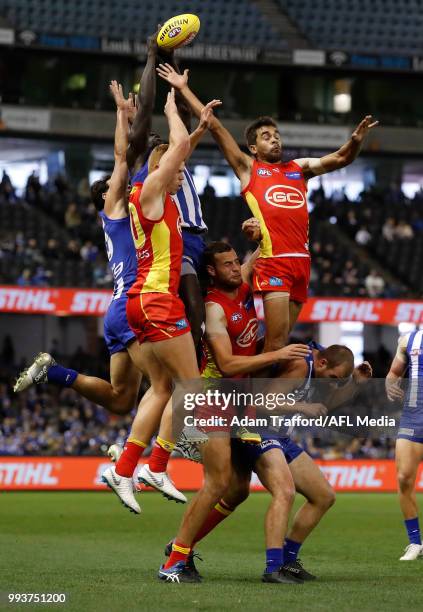 Majak Daw of the Kangaroos takes a huge mark over L-R Peter Wright, Jarrod Witts and Jack Martin of the Suns during the 2018 AFL round 16 match...