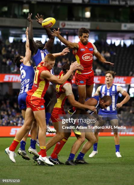 Majak Daw of the Kangaroos takes a huge mark over L-R Peter Wright, Jarrod Witts and Jack Martin of the Suns during the 2018 AFL round 16 match...