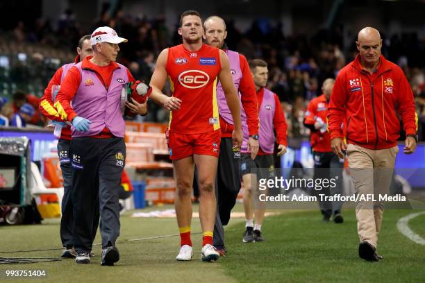 Steven May of the Suns leaves the field injured during the 2018 AFL round 16 match between the North Melbourne Kangaroos and the Gold Coast Suns at...