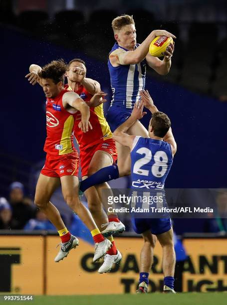 Jack Ziebell of the Kangaroos takes a strong mark over Jarrod Harbrow and Steven May of the Suns and Kayne Turner of the Kangaroos during the 2018...