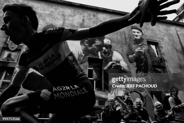 Spectators cheer as France's Romain Bardet of France's AG2R La Mondiale cycling team cycles past during the team presentation ceremony on July 5,...