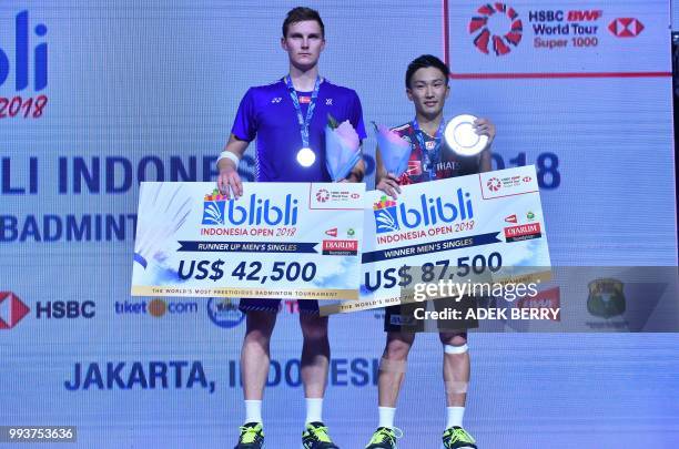 Runner up Viktor Axelsen of Denmark and winner Kento Momota of Japan pose after the men's singles badminton final match at the Indonesia Open in...