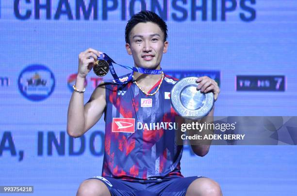 Winner Kento Momota of Japan poses after playing against Viktor Axelsen of Denmark during the men's singles badminton final match at the Indonesia...
