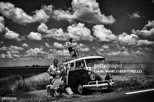 Spectators wait along the road to watch riders during the first stage of the 105th edition of the Tour de France cycling race between...