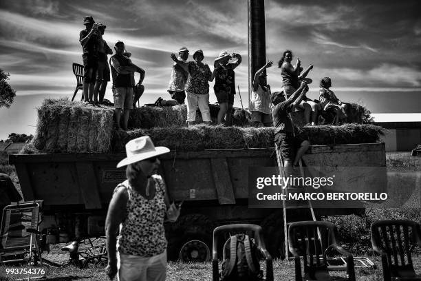 Spectators wait to watch riders along the route during the first stage of the 105th edition of the Tour de France cycling race between...