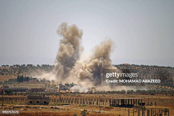 Smoke rises above rebel-held areas of the province of Daraa during reported airstrikes by Syrian regime forces on July 8, 2018. Syrian army soldiers...