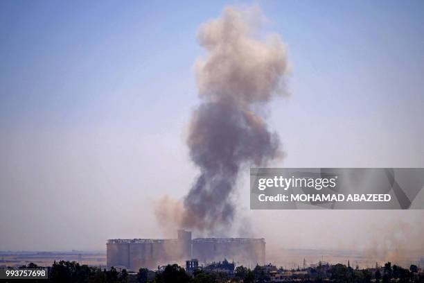 Smoke rises above rebel-held areas of the province of Daraa during reported airstrikes by Syrian regime forces on July 8, 2018. Syrian army soldiers...