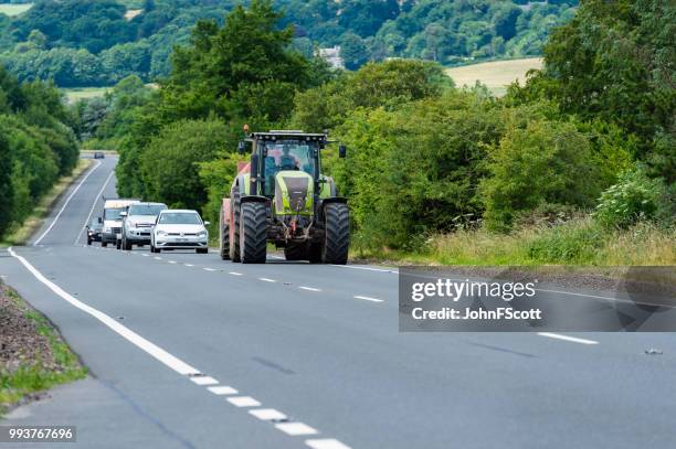 tractor pulling a trailer on a main scottish road - tractor stock pictures, royalty-free photos & images