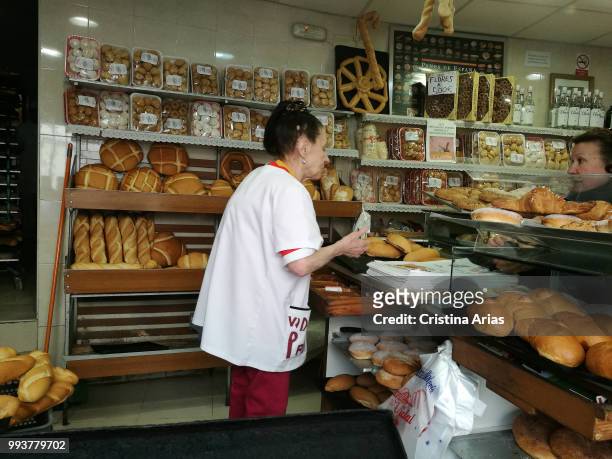 Woman selling bread in a bakery in Chinchon, Madrid, Spain.
