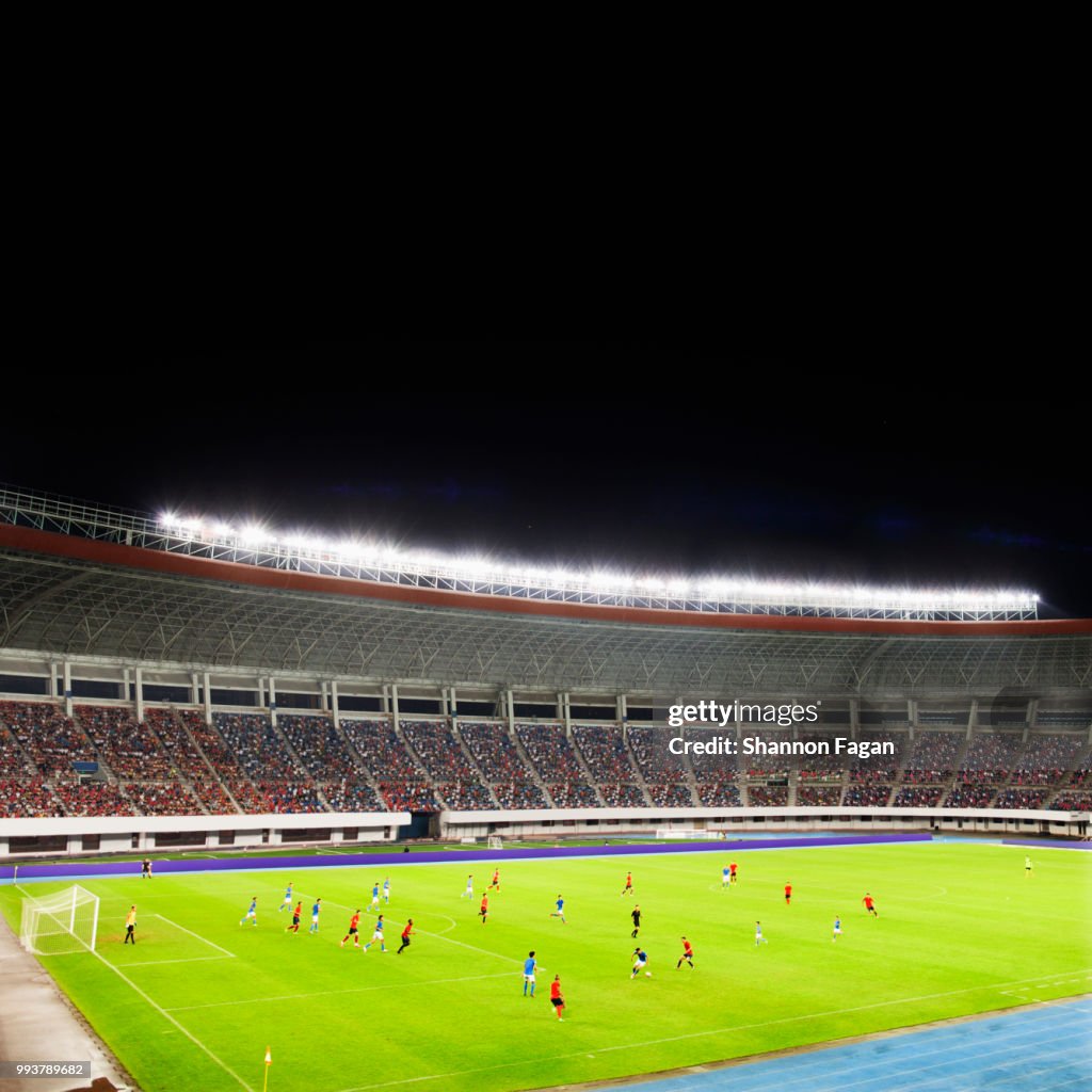 Soccer game in a stadium at night