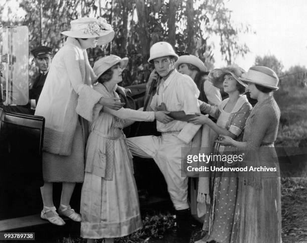 View of American actor Milton Sills , surrounded by unidentified actresses in a scene from the film 'What A Wife Learned' , Hollywood, California,...