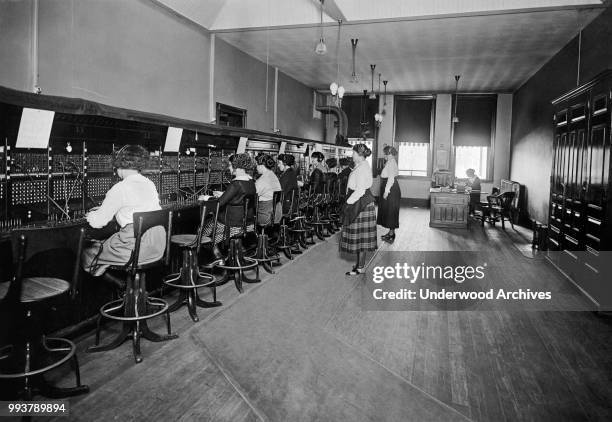 View of operators at an unspecified telephone switchboard, circa 1915.