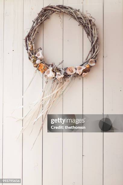 wooden wreath decorated with sea shells against light-colored wooden wall, greece - holzwand shabby chic stock-fotos und bilder