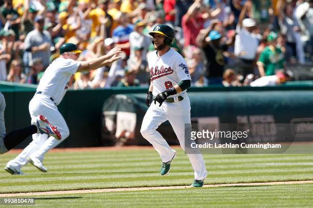 Jed Lowrie of the Oakland Athletics runs to home plate to score on a double hit by Stephen Piscotty in the eighth inning against the San Diego Padres...