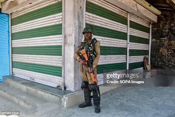 Paramilitary soldier stand guard during restrictions imposed on the eve of the second death anniversary of the rebel commander Burhan Muzaffar Wani...