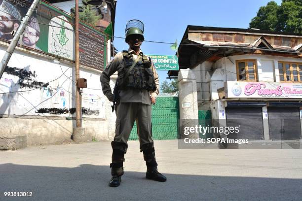 Indian paramilitary trooper stands guard during a curfew restrictions, on the second death anniversary of Burhan Muzaffar Wani a young rebel...