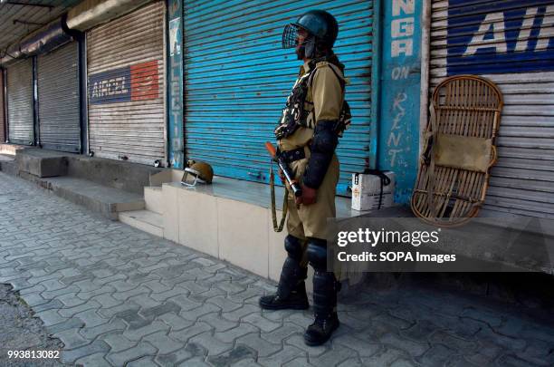 Indian paramilitary trooper stands guard during a curfew restrictions, on the second death anniversary of Burhan Muzaffar Wani a young rebel...