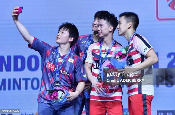 Takuto Inoue and Yuki Kaneko of Japan and Kevin Sanjaya Sukamuljo and Marcus Fernaldi Gideon of Indonesia take a selfie after the men's doubles...