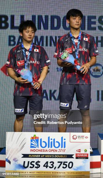 Silver medalists Takuto Inoue and Yuki Kaneko of Japan celebrate on the podium during the Men's Doubles awarding ceremony on day six of the Blibli...