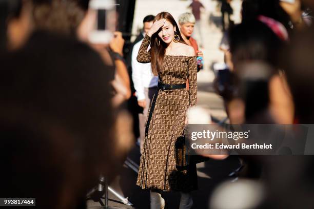 Jessica Jung wears a brown Fendi dress, a Fendi bag, and poses in front of fans outside Fendi, during Paris Fashion Week Haute Couture Fall Winter...