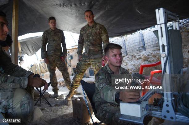 In this photo taken on July 7, 2018. US Army soldiers from NATO looks on as they use a cruise system in a checkpoint during a patrol against Islamic...